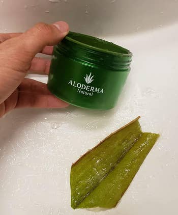 Hand holding a greenish  jar labeled 