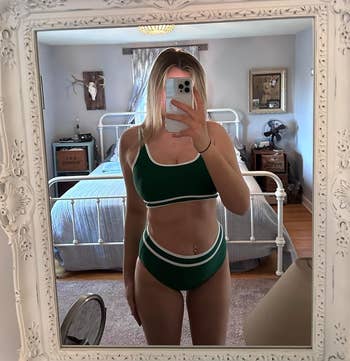 a reviewer wearing the two-piece set in green with white trim 