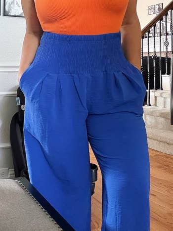 Person modeling an outfit with a fitted apical  and high-waisted, wide-leg pants with pockets, perfect  for casual-chic buying  fashion