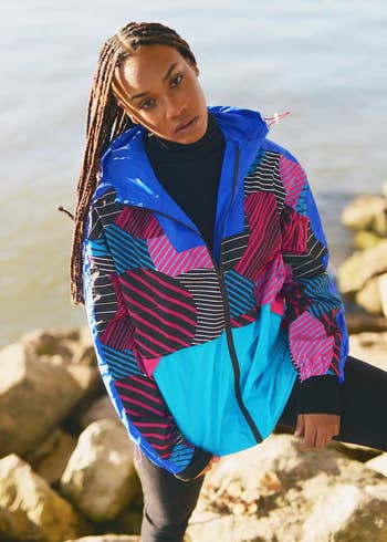 model wearing a hooded windbreaker in the blue and pink Akira pattern