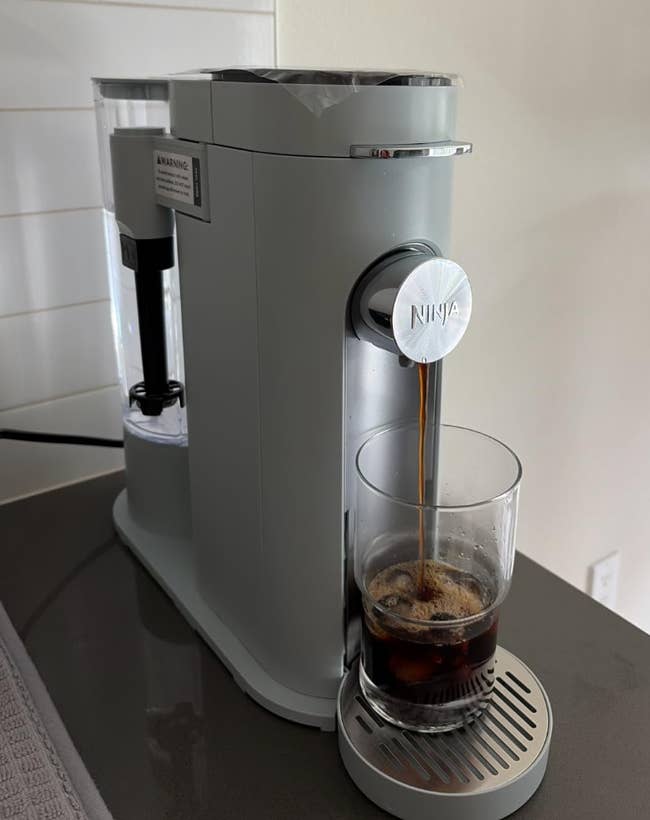 Coffee instrumentality dispensing java into a solid connected a room counter, highlighting location brewing convenience