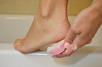 Model using loofah soap on heel of foot
