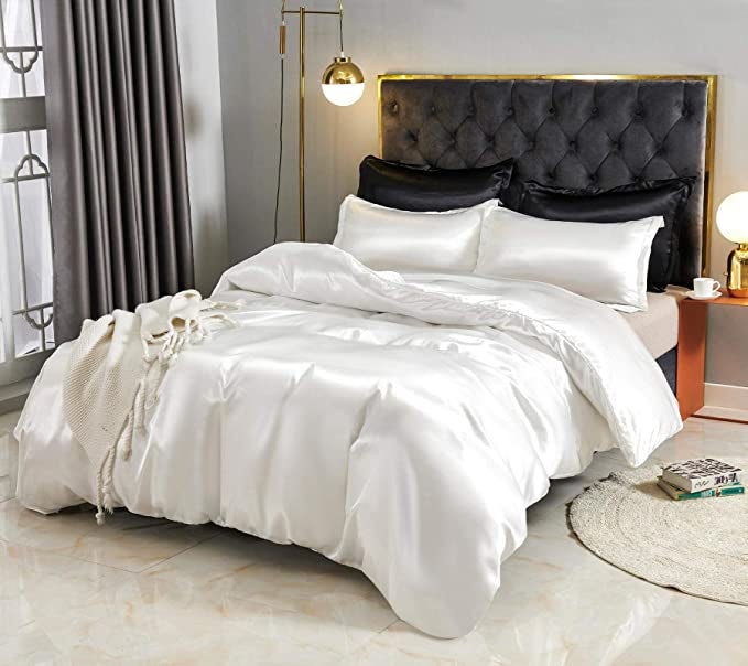 the white satin duvet cover set on a bed