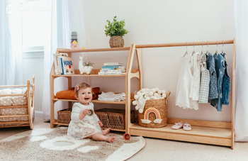 child sitting in front of wooden wardrobe and shelf