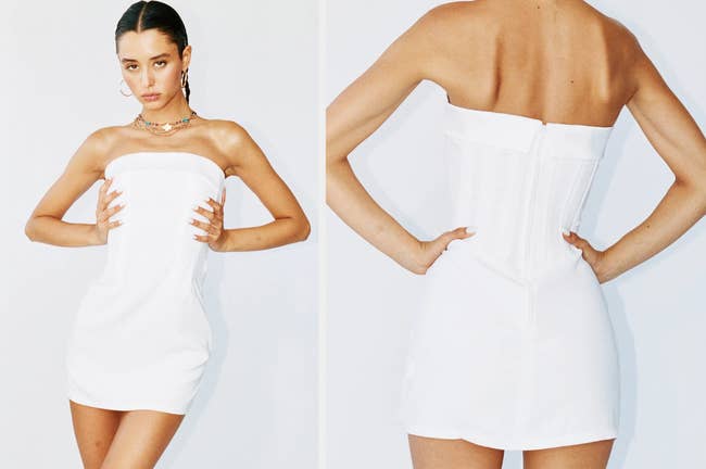 Model wearing white mini strapless white formal dress with folded over top and corset bodice, model showing back view of product with white zipper on a white background