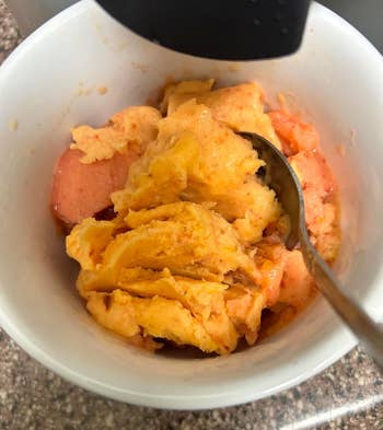 Bowl of freshly made peach and mango sorbet with a spoon