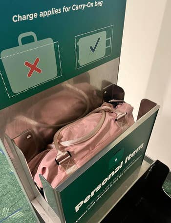 Bag fitting in baggage sizer labeled “Personal Item