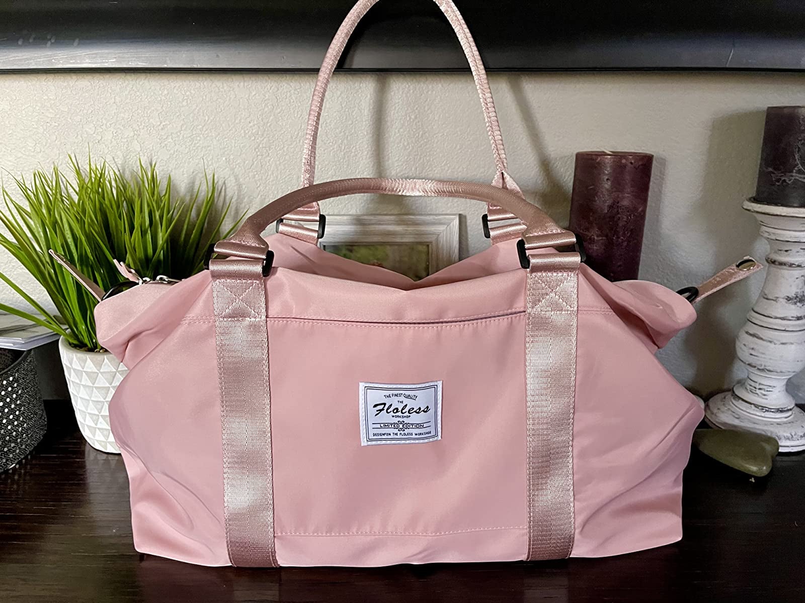 the pastel pink duffel bag with white logo tag