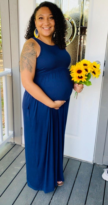 a pregnant reviewer wearing the dress in navy blue 