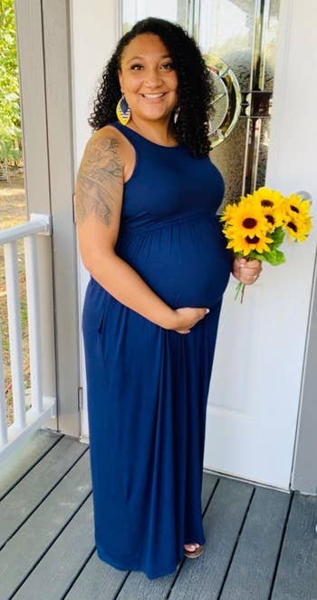 a pregnant reviewer wearing the dress in navy blue 