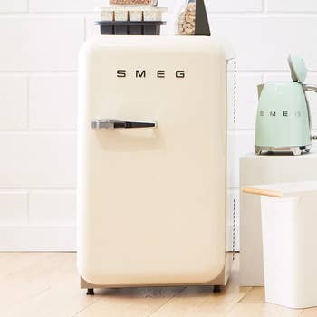 a cream-colored smeg mini fridge, closed