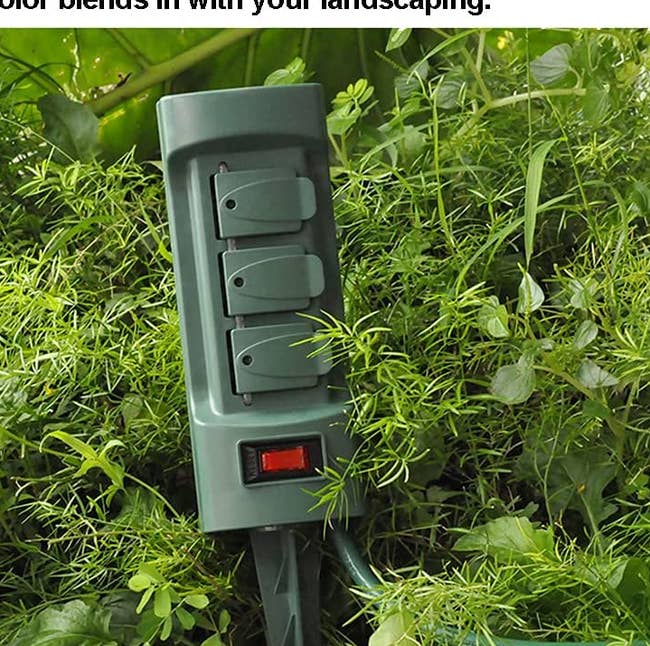 the power stake in a bush outside with the covers over each outlet