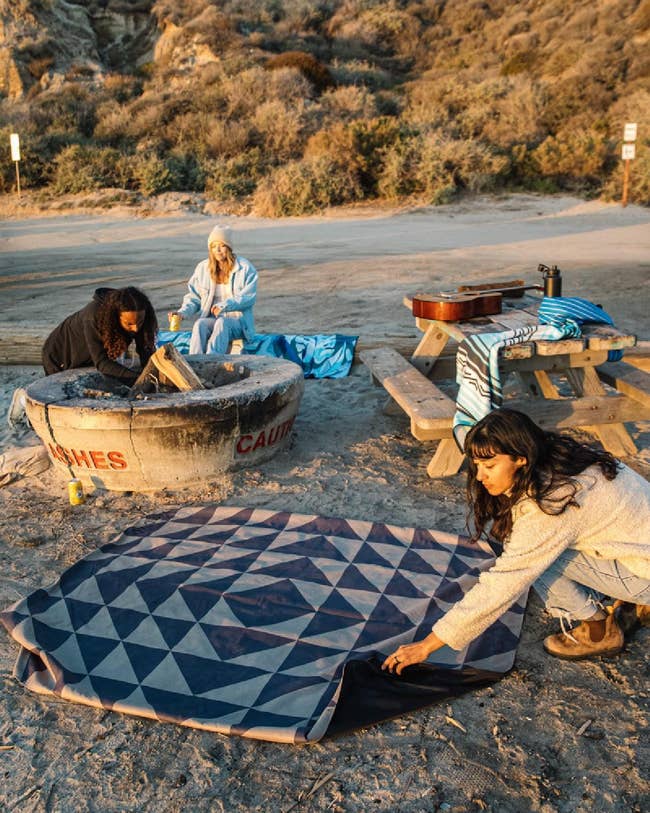 lifestyle image of people unfolding blanket at a campground