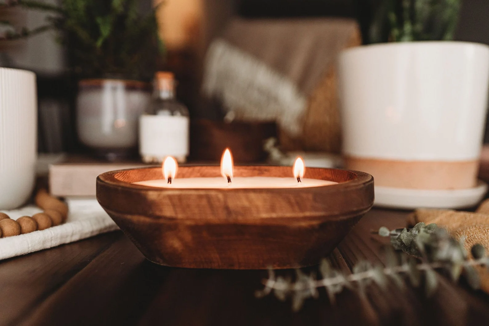 a lit candle placed in a wooden bowl
