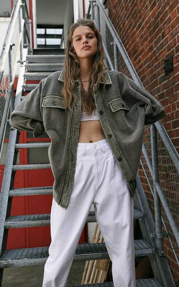 model wearing olive green shacket in front of stairwell