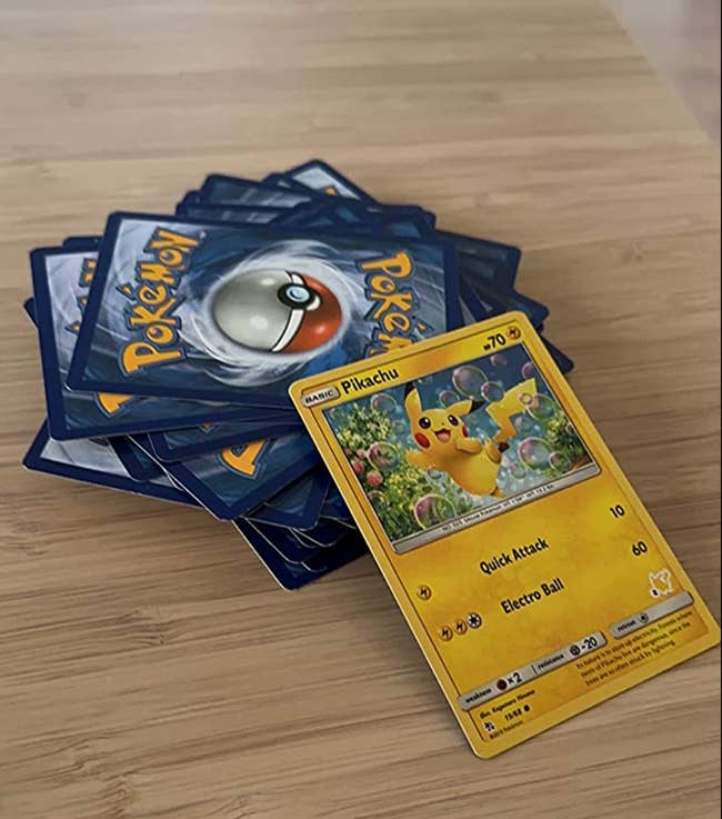 Pokemon cards in a stack with a Pikachu card on top 
