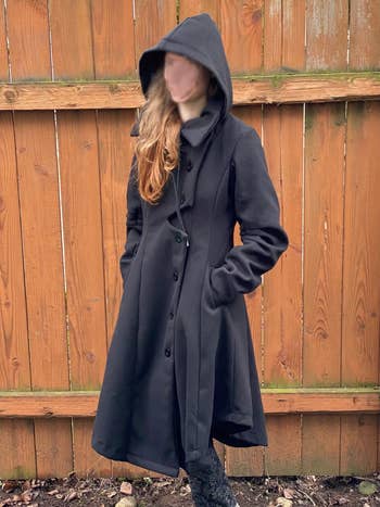 reviewer wearing longer coat with asymmetrical buttons and hood