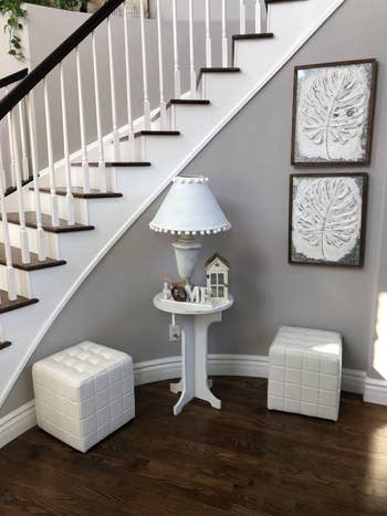 reviewer photo of two of the white ottomans under the stairs