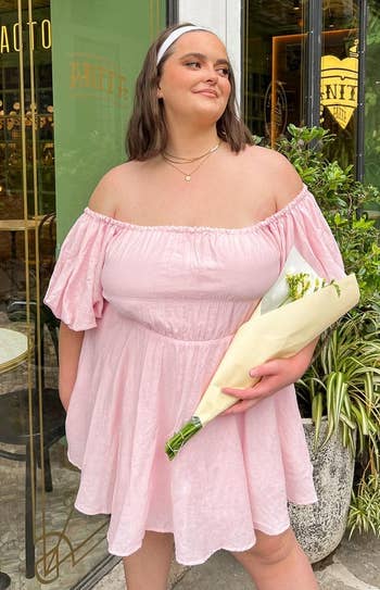 model posing with flower bouquet wearing pink dress