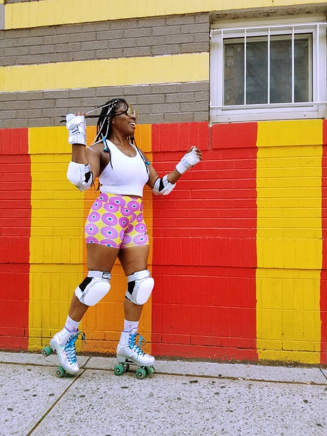 model wears yellow and pink-print bike shorts while wearing roller skates