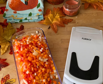 reviewer photo of a container full of diced veggies next to the chopper