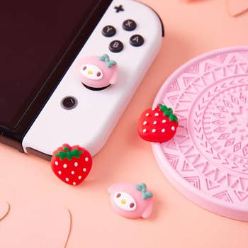 product photo showing two pairs of joystick caps that look like a sanrio character and strawberries