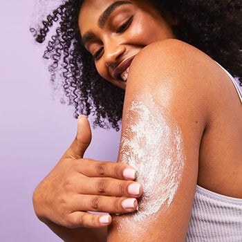 A model rubbing the cream into their arm