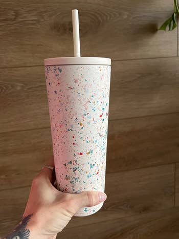 a reviewer's white terrazzo tumbler cup