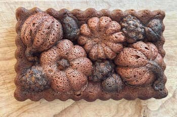 Baked breadstuff  shaped similar  assorted pumpkins and gourds connected  a woody  surface, showcasing elaborate  seasonal designs