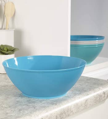 the blue bowl on a counter with the other five bowls in the set stacked in the background