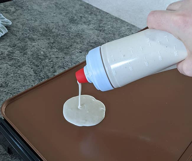 a reviewer pouring pancakes from the bottle