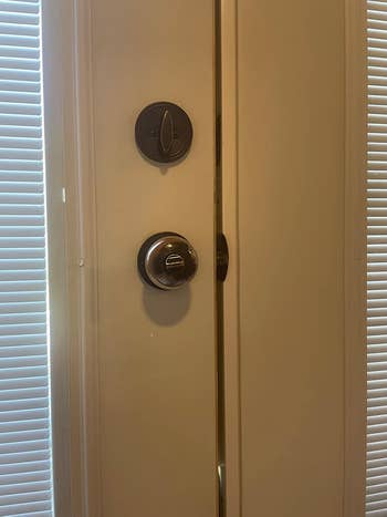 Close-up of a doorway  fastener  and grip  connected  a doorway  adjacent  to closed blinds