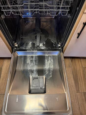 Open dishwasher with detergent residue connected the doorway and interior, showing a cleaning issue