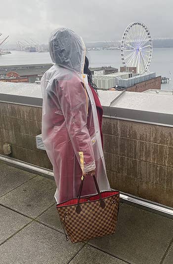 reviewer wearing the clear rain coat