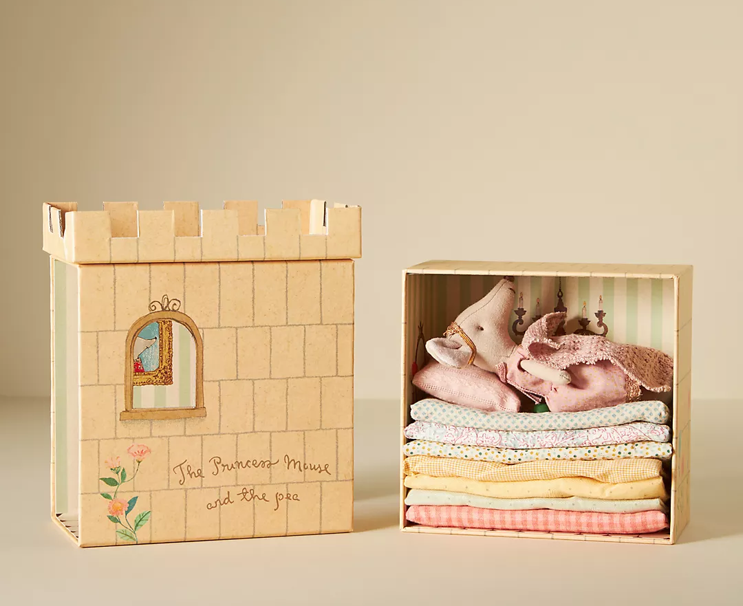 mouse doll on several mattress in castle shaped box