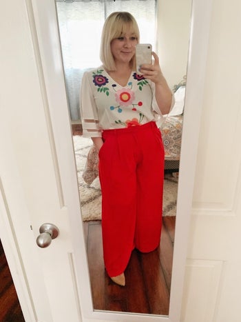 reviewer in bright red palazzo pants