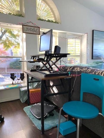 a reviewer photo of the standing desk on top of a desk 