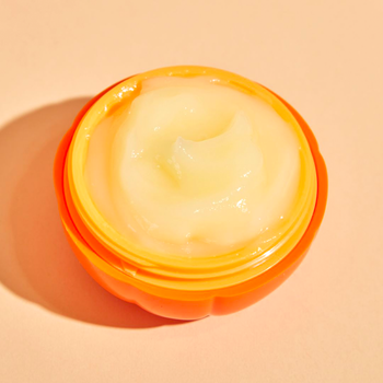 the jar open to show the creamy, slightly orange formula