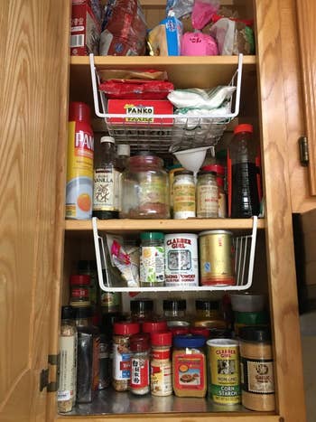 a reviewer photo of the baskets used in a spice cabinet 