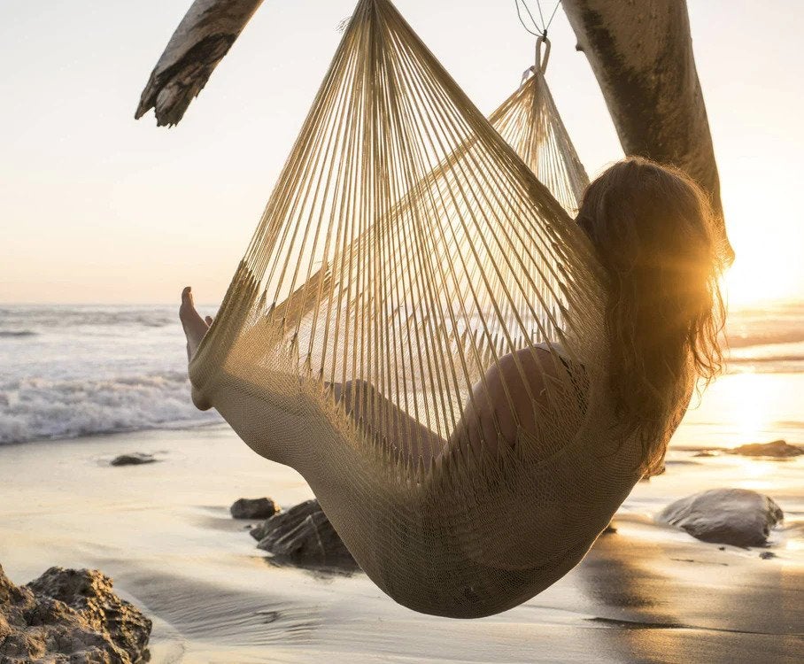 person sitting in hammock on beach
