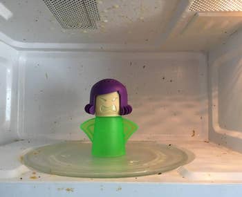 reviewer's before photo of the green angry mama in a dirty microwave