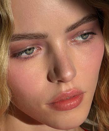 Close-up of a person's look   with brushed  constitution  and gentle lighting, showcasing their eyes, lips, and complexion