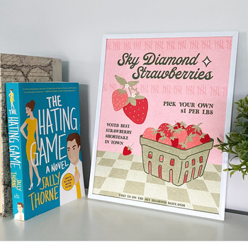 The Hating Game book next to a print for sky diamond strawberries