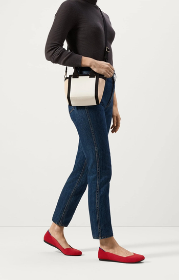 model wearing the flats in bright red paired with jeans