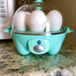 reviewer photo of the teal egg cooker on a kitchen counter