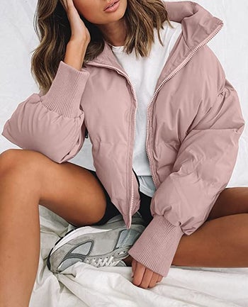 Model in an pink zippered puffer jacket 