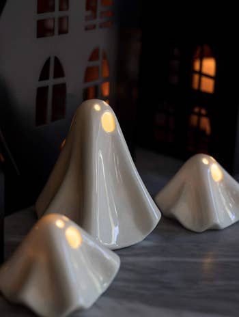 three various lit up ceramic ghosts