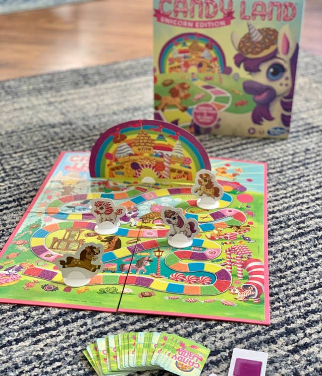 Candy Land Unicorn Edition game setup with board, character pieces, cards, and box shown