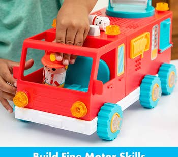 Child model playing with plastic red fire truck toy