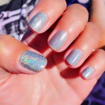 reviewer's hand with a holographic silver nail polish on their nails